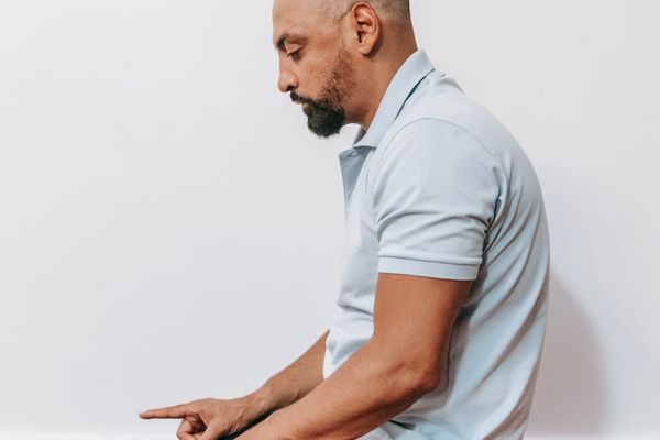 Person sitting in a meditative lotus pose, viewed from the side.